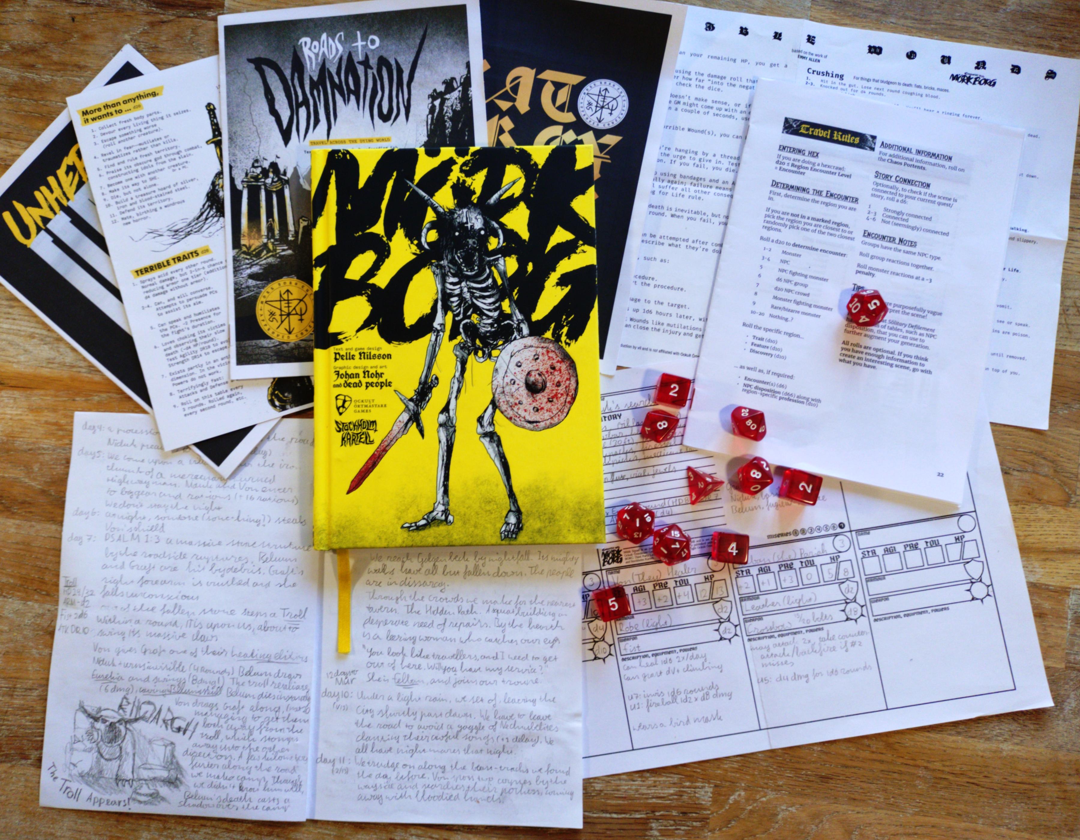 A photo of the materials I used to play Mörk Borg. The book lies on a table, surrounded by various printed materials and a number of dice.